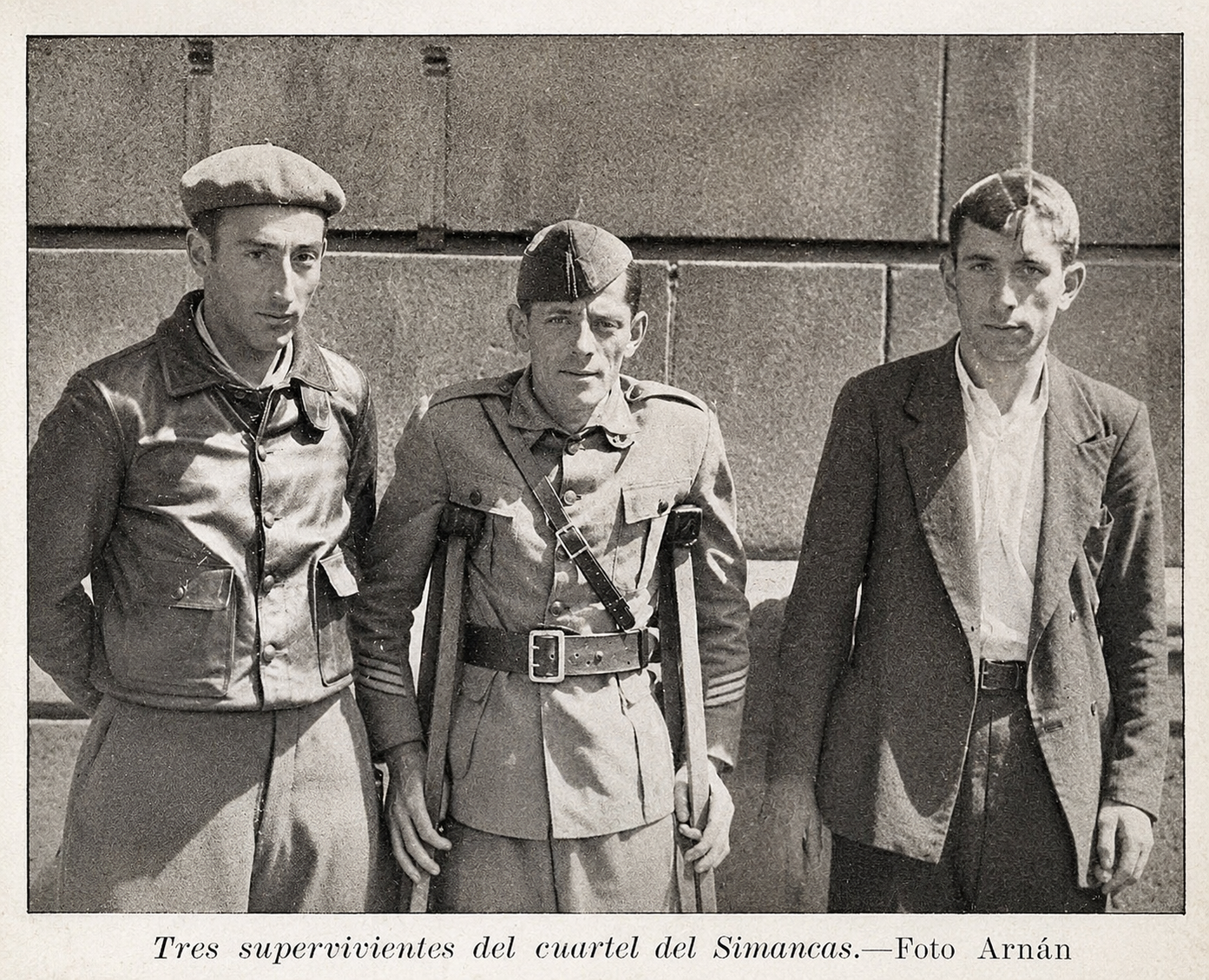Tres supervivientes del cuartel del Simancas posando ante un muro de sillería.